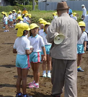 2018年度鹿室コスモス祭りへの準備が始まりました。9月6日に2018年度コスモス祭りになるコスモス畑に園児たちが種を蒔いている写真27枚目。