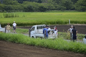 コスモスの種を蒔く無人ヘリを下ろしている写真。